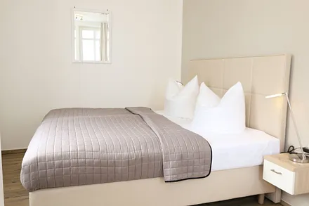 Schlafzimmer mit Doppelbett (2 x 0,90 m x 1,80 m), Nachtischkonsolen und geräumiger Kleiderschrank