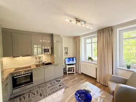 Küchenzeile mit Geschirrspüler, Backofen, 4-Zonen-Ceranfeld, Kühlschrank mit Eisfach, Kaffeemaschine, Mikrowelle, Toaster, Wasserkocher und diversen Küchenutensilien