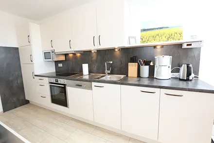 Küchenzeile mit Mikrowelle und diversen  Küchenutensilien