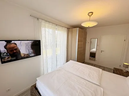 Schlafzimmer mit Doppelbett (2x 0,90 m x 2,00 m) in Komforthöhe (60cm) und zwei 7-Zonenkaltschaummatratzen,Nachttischablagen,Kleiderschrank,Wandspiegel und 40 Zoll LED - Flachbild TV