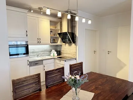 Küchenzeile mit Kühlschrank und Gefrierfach, Cerankochfeld, Backofen, Geschirrspüler, Wasserkocher, Toaster, Kaffeemaschine, Handmixer, Kindergeschirr und Besteck und diversen Küchenutensilien