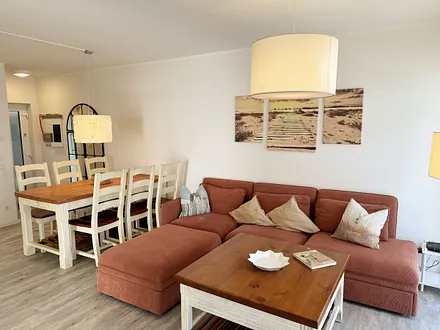 Wohnbereich mit Massivholzmöbeln mit großer Couch, Couchtisch, Leselampe, 4K UHD LED Smart-TV, Soundbar, CD/DVD/Blu-Ray-Player