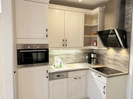 Küchenzeile mit Kühlschrank und Gefrierfach, Backofen, Geschirrspüler, Mikrowelle, Cerankochfeld, Kaffeemaschine, Thermoskanne, Wasserkocher, Teekanne, Toaster sowie diverse Küchenutensilien