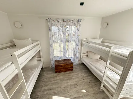 Schlafzimmer mit zwei Etagenbetten, Kleiderschrank, Schatzkiste mit Spielsachen, 2 Kinderreisebetten (mit Matratzen), Wickelkommode