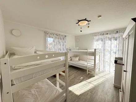 Schlafzimmer mit zwei Etagenbetten, Kleiderschrank, Schatzkiste mit Spielsachen, 2 Kinderreisebetten (mit Matratzen), Wickelkommode