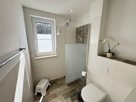 Tageslichtbadezimmer mit ebenerdiger Dusche, WC, Spiegel, Kosmetikspiegel, Waschtisch mit Schubladen, Haartrockner und Handtuchwärmer