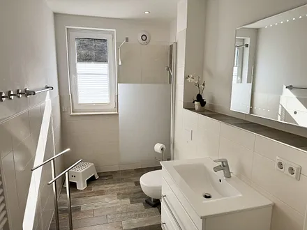 Tageslichtbadezimmer mit ebenerdiger Dusche, WC, Spiegel, Kosmetikspiegel, Waschtisch mit Schubladen, Haartrockner und Handtuchwärmer