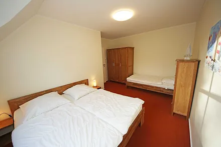 Schlafzimmer mit Doppelbett (2x 0,90 m x 2,00 m), verstellbare Lattenroste, Nachtischablagen, Kleiderschrank und zusätzlichem Einzelbett (0,90 m x 2,00 m) sowie Insektenschutzgitter
