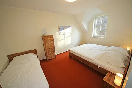 Schlafzimmer mit Doppelbett (2x 0,90 m x 2,00 m), verstellbare Lattenroste, Nachtischablagen, Kleiderschrank und zusätzlichem Einzelbett (0,90 m x 2,00 m) sowie Insektenschutzgitter