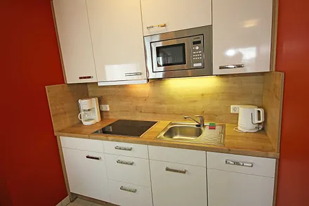 moderne Küchenzeile mit Geschirrspüler,Ceran-Kochfeld,Dunstabzugshaube,Kühlschrank mit Eisfach,Spüle,Mikrowelle,Toaster,Wasserkocher,Kaffeemaschine sowie diversen Küchenutensilien