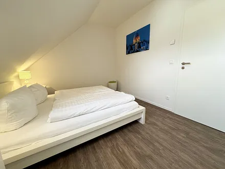 Schlafzimmer mit Doppelbett (1,60 m x 2,00 m), geräumigen Kleiderschrank und Wecker