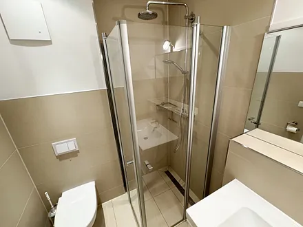 modernes Badezimmer mit Lüftung, bodengleicher Regendusche, WC, Handtuchtrocknerheizung, Waschmaschine, Fön und Waschtisch