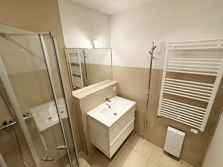 modernes Badezimmer mit Lüftung, bodengleicher Regendusche, WC, Handtuchtrocknerheizung, Waschmaschine, Fön und Waschtisch