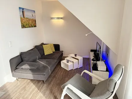 Wohnbereich mit Couch, Kaminofen, Smart-TV, Blu-Ray-Player u.a. mit CD- und Radiofunktion sowie Gesellschaftsspielen