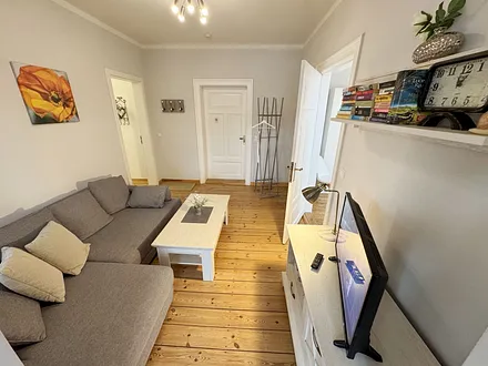 Wohnzimmer mit gemütlicher Couch und Flachbild-TV