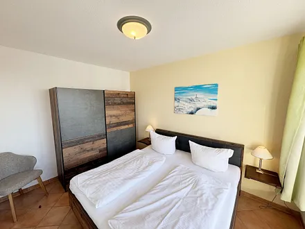 Schlafzimmer mit Doppelbett und Kleiderschrank