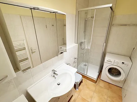 Badezimmer mit Dusche und Waschmaschine