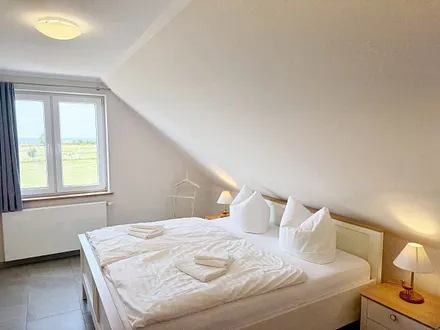 Schlafzimmer mit Doppelbett und Nachttischkonsolen
