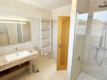 Badezimmer mit Waschbecken und Dusche