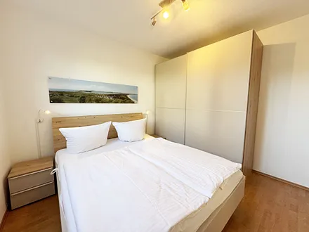 Schlafzimmer mit Doppelbett und Nachttischablagen