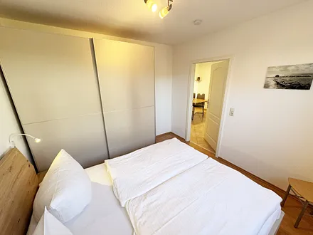 Schlafzimmer mit Doppelbett und Schwebetüren-Kleiderschrank