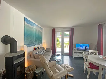 Wohnbereich mit gemütlicher Couch, Couchtisch, Relaxsessel, LCD-Flachbild-TV, Blu-Ray-Player, Mini-Stereo-Anlage mit USB-Anschluss und kleine Spielesammlung