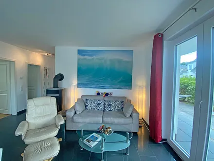 Wohnbereich mit gemütlicher Couch, Couchtisch, Relaxsessel, LCD-Flachbild-TV, Blu-Ray-Player, Mini-Stereo-Anlage mit USB-Anschluss und kleine Spielesammlung