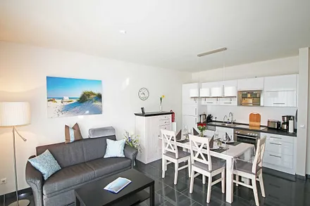 Wohnraum mit gemütlicher Couch, Leselampe, Smart-TV, Blu-Ray-Player und einer Stereoanlage mit DAB-Radio