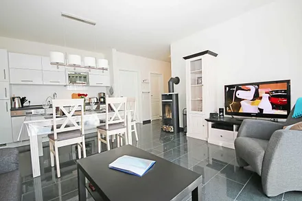 Wohnraum mit gemütlicher Couch, Leselampe, Smart-TV, Blu-Ray-Player und einer Stereoanlage mit DAB-Radio