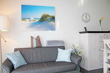 Wohnraum mit gemütlicher Couch, Leselampe, Smart-TV, Blu-Ray-Player und einer Stereoanlage mit DAB-Radio