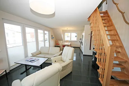 Wohnraum mit gemütlicher Couch, Sessel, LED-TV und Stereoanlage