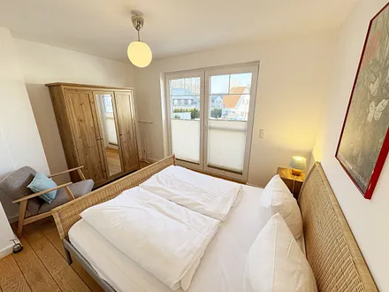 Schlafzimmer mit Doppelbett und Kleiderschrank