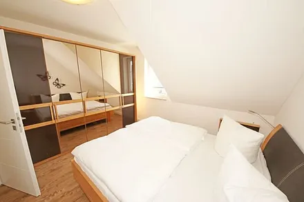 Schlafzimmer mit Doppelbett mit Tempur-Matratzen (2 x 0,90 m x 2,00 m), 2 Nachttischablagen und Panorama - Spiegelschrank