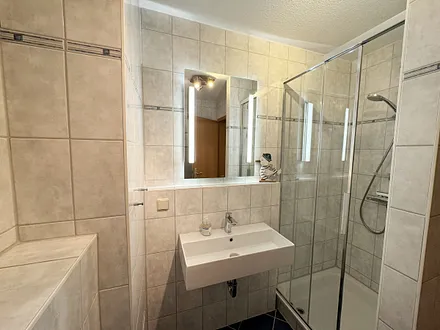 Badezimmer mit Dusche, Waschtisch, Kosmetikspiegel, Fön und WC