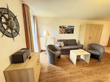 Wohnbereich mit Schlafsofa  (1,50m x 1,90m), Couchtisch und Flachbild – TV