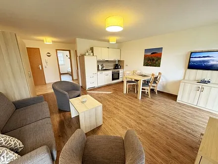 Wohnbereich mit Schlafsofa  (1,50m x 1,90m), Couchtisch und Flachbild – TV