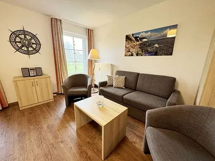 Wohnbereich mit Schlafsofa  (1,50m x 1,90m), Couchtisch und Flachbild – TV