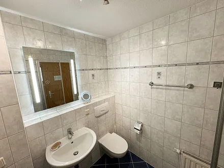 Badezimmer mit Dusche, Waschtisch, Fön und WC 