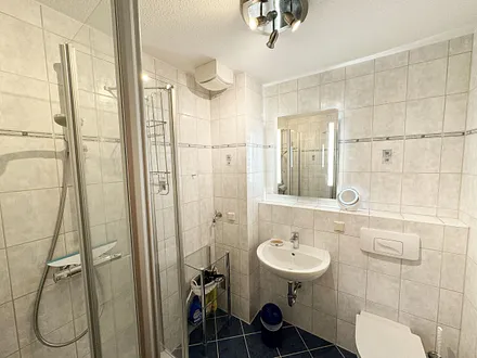 Badezimmer mit Dusche, Waschtisch, Fön und WC 