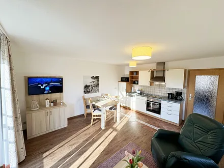 Wohnbereich mit Schlafsofa (Aufbettungsmöglichkeit für die 3./4. Person, 1,50m x 1,90m), Couchtisch und Flachbild – TV