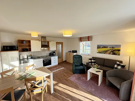 Wohnbereich mit Schlafsofa (Aufbettungsmöglichkeit für die 3./4. Person, 1,50m x 1,90m), Couchtisch und Flachbild – TV