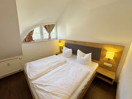 Schlafzimmer mit Doppelbett und Nachttischkonsolen