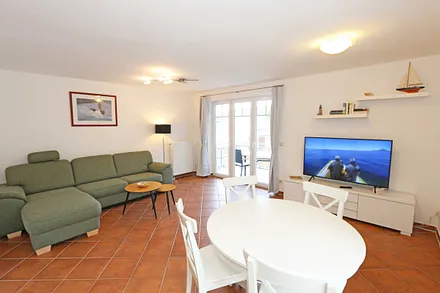 Wohnzimmer mit Eckcouch und Ausziehfunktion (1,15 m x 2,20 m, Aufbettung für die 3./4. Person), Couchtisch, Leselampe, Smart-TV, Blu-Ray Player sowie Mini-Stereo-Anlage