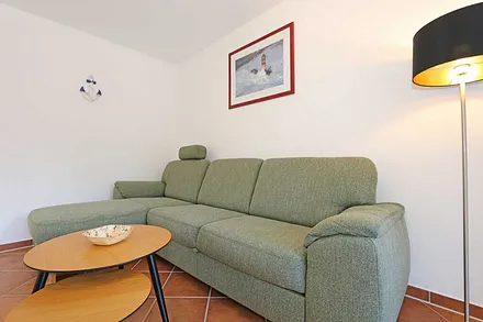 Wohnzimmer mit Eckcouch und Ausziehfunktion (1,15 m x 2,20 m, Aufbettung für die 3./4. Person), Couchtisch, Leselampe, Smart-TV, Blu-Ray Player sowie Mini-Stereo-Anlage