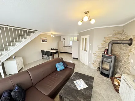 Wohnzimmer mit gemütlicher Couch, Smart-TV, DAB Radio, Blu-Ray-Player sowie ein direkter Zugang über die Schiebetür auf die Terrasse