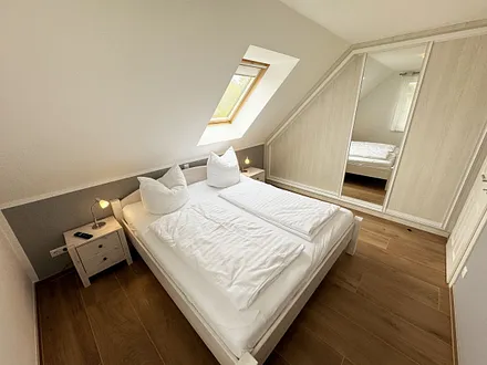Schlafzimmer mit Doppelbett (1,80 m x 2,00 m), Kleiderschrank und Komode