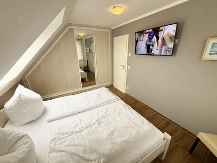 Schlafzimmer mit Doppelbett (1,80 m x 2,00 m), Kleiderschrank und Komode