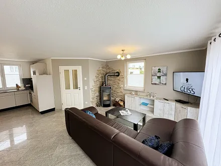 Wohnzimmer mit gemütlicher Couch, Smart-TV, DAB Radio, Blu-Ray-Player sowie ein direkter Zugang über die Schiebetür auf die Terrasse