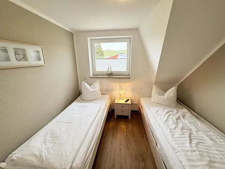 Schlafzimmer mit Einzelbett und einem Tandembett (Einzelbett mit Ausziehfunktion, je 0,90 m x 2,00 m) und einer Kommode 