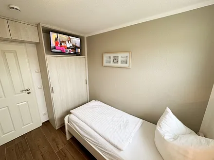 Schlafzimmer mit Einzelbett und einem Tandembett (Einzelbett mit Ausziehfunktion, je 0,90 m x 2,00 m) und einer Kommode 